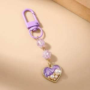 Detailed close-up of a purple heart keychain with crackle beads and faux pearl inlay