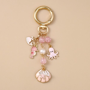 Porte-clés série océan doré avec poulpe en émail rose, hippocampe et breloque en perle
