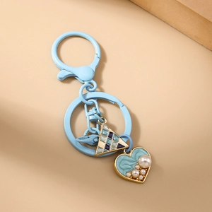Detail of light blue heart keychain with faux pearls and geometric triangle charm