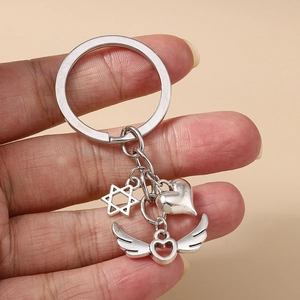 Gros plan d'un porte-clés en métal argenté avec pendentifs en étoile et cœur ailé