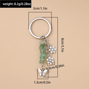Détail des perles en turquoise avec pendentifs papillon et fleurs en argent sur le porte-clés
