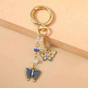Detailansicht goldener Schmetterling-Schlüsselanhänger mit blauem Glitzer und Emaille