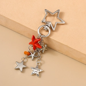 Détail du mousqueton étoile avec étoile de mer rouge et pendentifs gravés love you