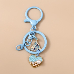 Detail of light blue heart keychain with faux pearls and geometric mosaic triangle charm