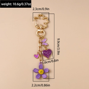 Detailansicht der Schlüsselanhänger-Größe mit lila Emaille-Blumen, Herz- und Schmetterling