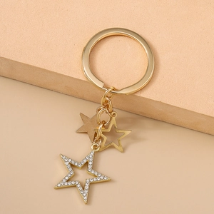 Gros plan d'un porte-clés doré avec étoile en strass et pendentifs ajourés élégants