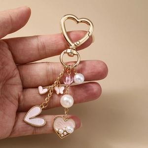 Mode-Schlüsselanhänger mit rosa Herzanhängern und weißen Perlen auf Goldmetallkette