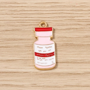 Gros plan détaillé d'un pendentif flacon de médicament en émail rouge et bord doré