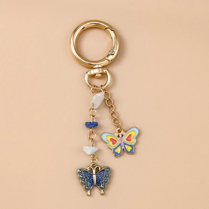 Detail eines goldenen Schmetterling Schlüsselanhängers mit Emaille und Perlen verzierung