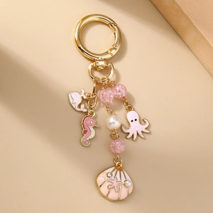 Détail du porte-clés hippocampe rose et coquillage doré avec perles élégantes