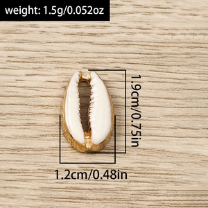 Macro detail of white enamel shell pendant with gold edges and dimensions on wood