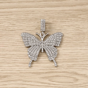 Detailed macro view of butterfly charm pendant featuring sparkling clear rhinestones on silver base
