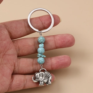 Vue détaillée d'un porte-clés éléphant boho avec perles turquoise tenu à la main
