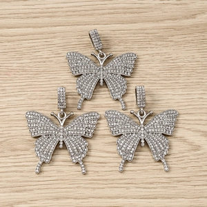 Detailed macro view of three sparkling silver butterfly pendants with white rhinestones