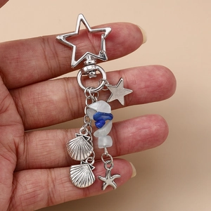Détail d'un porte-clés thème marin avec boucle étoile, coquillages et perles bleues