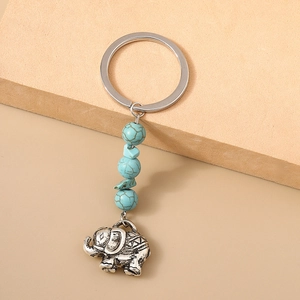 Vue détaillée du pendentif éléphant en métal vintage avec perles turquoise et anneau