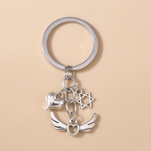 Détail d'un porte-clés en alliage argenté avec pendentifs cœur, hexagramme et cœur ailé