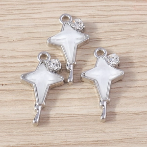 Set of shiny silver rhinestone star charms for DIY jewelry making on wooden background