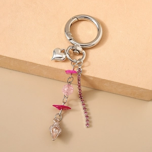 Détail des perles roses, pendentif cœur et coquille argentée sur le porte-clés