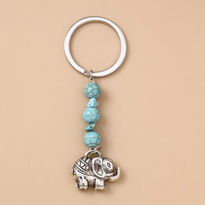 Vue détaillée du porte-clés argenté avec perles turquoise et breloque éléphant