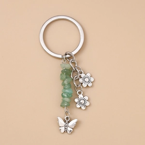 Détail d'un pendentif papillon argenté avec perles en pierre naturelle verte sur porte-clés