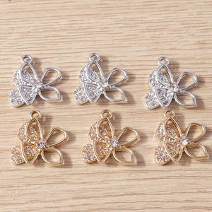 Macro-detail van holle vlinderbedeltjes met witte strassteentjes in goud en zilver