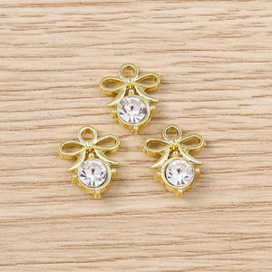 Detailed close-up of three golden bow pendants with sparkling crystal rhinestones