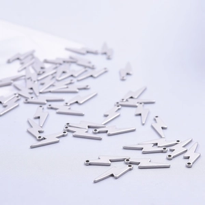 Silver stainless steel lightning bolt charms for DIY jewelry making on purple fabric