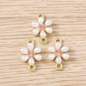 Macro detail of floral jewelry connectors with white petals and pink center rhinestone