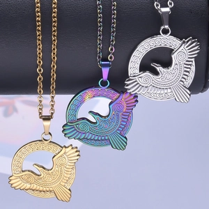 Three eagle pendant necklaces in gold, silver, and rainbow finishes on display