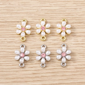Detailed view of six flower pendants with white pearl petals and pink rhinestone centers