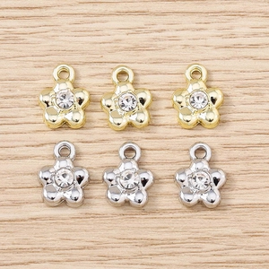 Macro view of six rhinestone flower charms in gold and silver for DIY jewelry