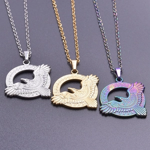 Detailed view of three stainless steel eagle pendants in silver, gold and rainbow finishes