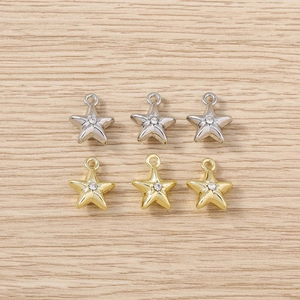 Close-up of gold and silver star pendants with rhinestones on a wooden background