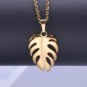 Macro shot of 18k gold plated monstera leaf pendant with hollowed out vein details