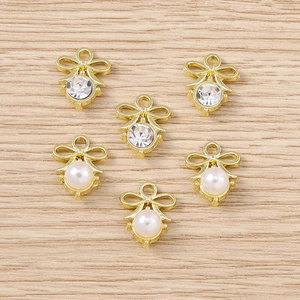 Bow-shaped golden alloy pendants with sparkling rhinestones and white pearls, set of six