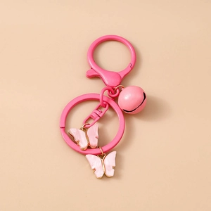 Detail of pink butterfly keychain with acrylic pendants and a small bell on metal ring