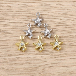 Flat lay of star-shaped pendants with rhinestones in gold and silver finish on wood