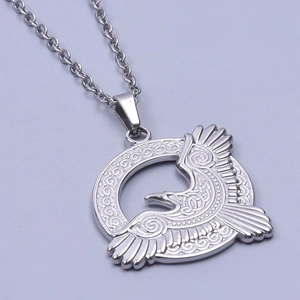 Macro detail of silver eagle pendant showing intricate Celtic engravings and steel finish