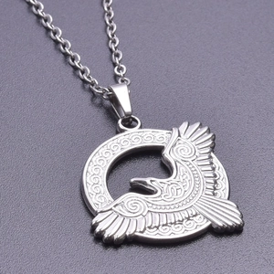 Macro detail of vintage eagle pendant with Celtic knot patterns and silver O-chain necklace