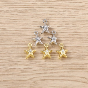 Close-up of star-shaped jewelry charms in gold and silver with sparkling rhinestones