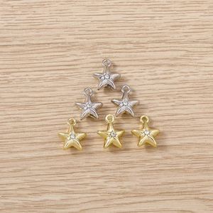 Macro view of gold and silver star pendants with tiny rhinestones on a wooden background