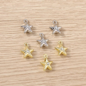 Macro shot of gold and silver star pendants with small crystal centers for jewelry