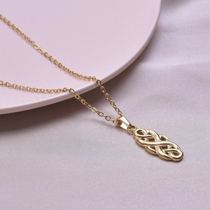 Detailed close-up of a 18k gold plated stainless steel witch knot necklace pendant