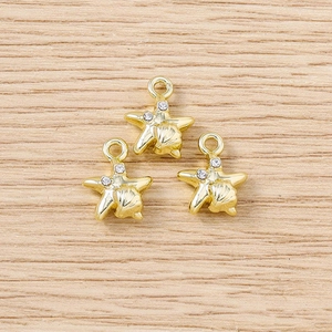 Detailed macro view of three golden star pendants with sparkling rhinestones for DIY jewelry