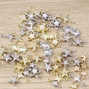 Macro shot of assorted gold and silver star charms with pearls for DIY jewelry making