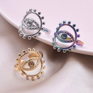 Detailed view of evil eye rings in gold, silver, and rainbow finishes on silk