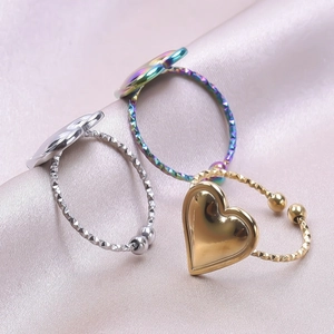 Detailed macro view of heart-shaped rings in gold, silver, and rainbow plating on pink satin