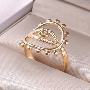 Macro shot of gold Evil Eye open ring with beaded edges in a beige jewelry box