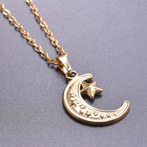Close-up of 18k gold plated stainless steel crescent moon and star pendant detail